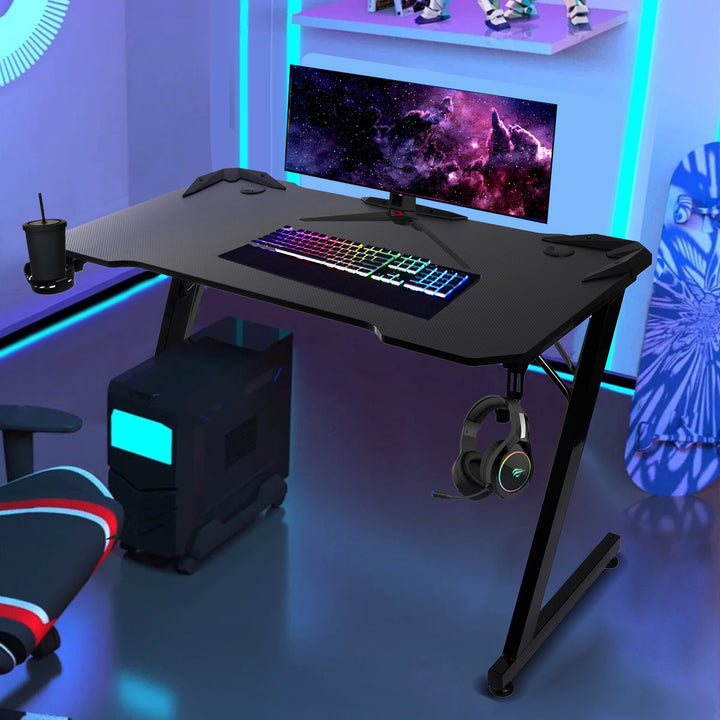 Découvrez le grand pupitre de jeu noir NanoRS. Supportant jusqu'à 150kg, hauteur ajustable (750mm), dimensions spacieuses (110x60x1.5cm), avec porte-gobelet et casque intégrés. Modèle : RS345.